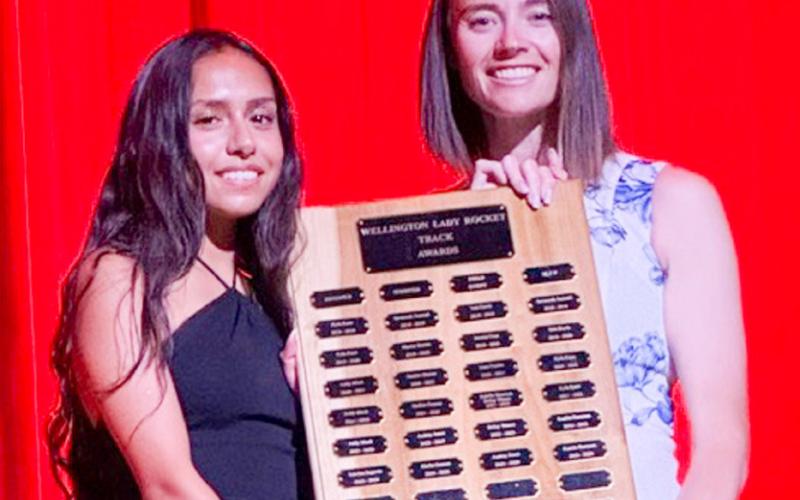 Wellington High School senior Sabrina Segovia accepts the Girls’ Track Distance Runner Award, presented by Coach Courtney Head.