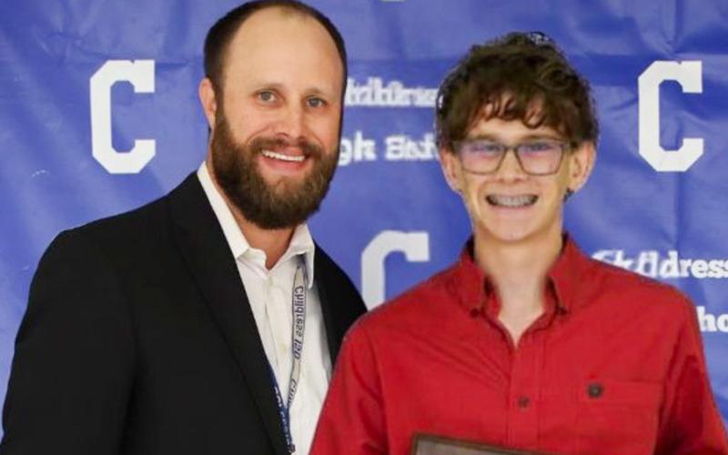 Hudson Elliott receives the Bobcat Cross County Most Valuable Player Award, presented by Athletic Director Bo Helm.