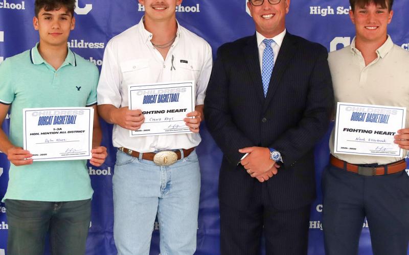 Dylan Moore, Crewz Keys and Noah Ellerbrook receiving the Bobcat Basketball Fighting Heart Award, presented by Bobcat Head Basketball Coach Colby Schneiderjan.