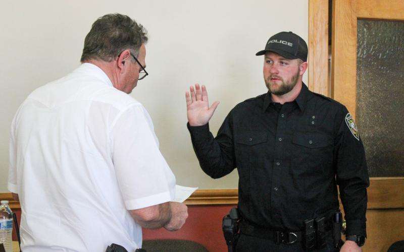 Childress Police Chief Jerrald Johnson swears in new officer Preston Bradley during the Childress City Council meeting Wednesday, March 25 at Childress City Hall. Bradley was joined by his family, including wife Kalin Bradley who pinned on his badge. The Red River Sun/Elizabeth Tanner