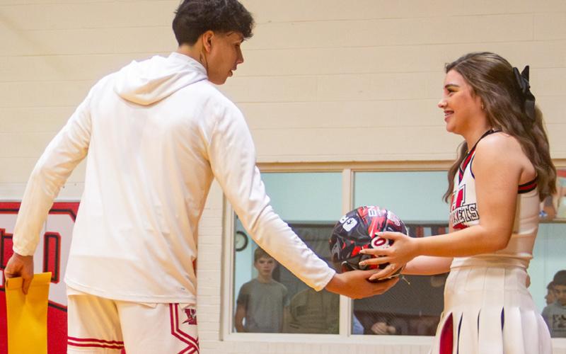 Senior cheerleader Treylea Wiebe accepts a basketball from classmate Tiny Hinojosa. The daughter of Henry and Amanda Wiebe, the teams expressed their appreciation to Treylea for cheering the Lady Rockets and Rockets to victory all these years.