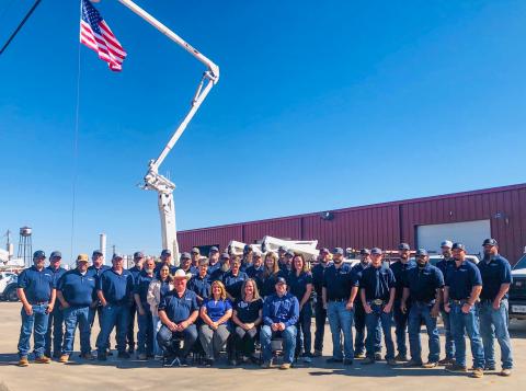 As Old Glory waves in the wind, the Greenbelt Electric Cooperative staff gathers Friday morning, Oct. 26, prior to its 86th Annual Meeting drive-through event. 