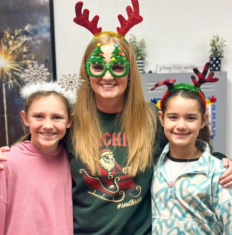 Wellington Elementary School Principal Deidre Kane gathers with fifth-graders Raylie Sims, left, and Summer Valles on Thursday, Dec. 18 for “Holiday Headgear… Spread the Cheer!” prior to the Friday, Dec. 19 release for the Christmas holiday. Teachers return to work Monday, Jan. 5, while students return Tuesday, Jan. 6. 