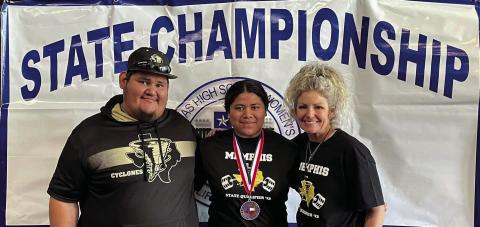 Senior powerlifter Emili Martinez, coached by assistant powerlifting coach Jose Duran, left, and powerlifting coach Michelle Branigan, right, brings home a fourth-place finish in weight class 198.