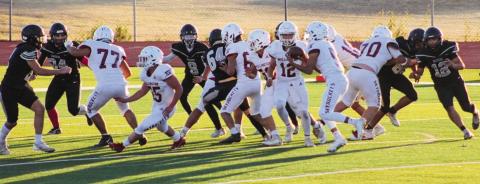 Junior varsity Skyrocket Lawson Inman (12) hands the ball off to Alex Orozco (5) in the game last Thursday, Halloween night, Oct. 31, in Canyon, where Wellington manhandled 4A Randall, taking a 24-12 win. Rockets Christopher Reyes (77), Dakota Ledbetter (55), Jr. Vega (50), Aison Skelton (70) and Jake Chandler (10) clear the way for Orozco. The Red River Sun/Shauna Salinas
