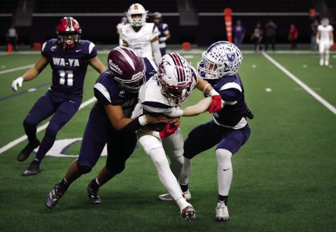 Wa-Ya defensive back Cooper O’Neal, right, of Wills Point High School, tackles Ta’Tanka wide receiver TJ Salinas (center), of Wellington High School, during the first half of the Native American All-Star Football Game at the Ford Center at The Star in Frisco on Tuesday, Jan. 7. Photo by Dallas News Staff Photographer Tom Fox