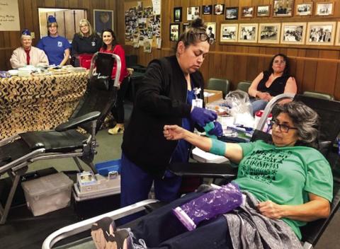 Irma Thomas completes her blood donation during the 12 Days of Christmas Coffee Memorial Blood Center drive at VFW Post 6439. Members of the Post Auxiliary, in the background, include Diane Vanderplaats, Dawn Popwell and Doris Wilbur, plus Ashly Cantu and Lucy Owens (seated). The Red River Sun/Bev Odom