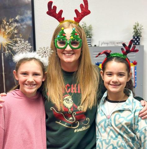 Wellington Elementary School Principal Deidre Kane gathers with fifth-graders Raylie Sims, left, and Summer Valles on Thursday, Dec. 18 for “Holiday Headgear… Spread the Cheer!” prior to the Friday, Dec. 19 release for the Christmas holiday. Teachers return to work Monday, Jan. 5, while students return Tuesday, Jan. 6. Wellington Elementary School