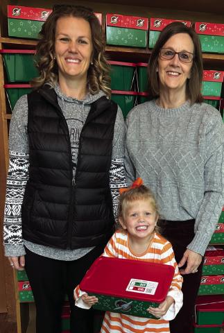 Three generations, including Jordan Conner, Wendy Langford and Kellyn Conner, prepare to transport 100 shoeboxes packed by the Wellington First Baptist Church congregation for delivery around the globe to impoverished children by Samaritan’s Purse Operation Christmas Child ministry. Courtesy Photo
