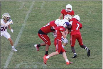 Junior varsity Rockets Kamron Brooks (7), Conner Bowen (11), Yobani Moreno (77), with other Rockets coming in to assist, take down a Panhandle Panther in a game on home turf last Thursday, Sept. 22. Wellington took the 28-20 win to remain undefeated on the season. The Red River Sun/Shauna Salinas