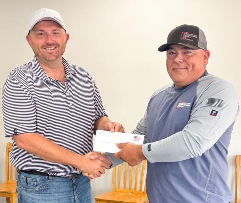 Wellington City Manager Justin Mixon, left, accepts a $10,000 monetary donation in support of the Ellison Park Renovation Project from local AEP-SWECO Lineman Mikey Garza. As citizens of the communities they serve, AEP-SWEPCO strives to donate to nonprofit organizations that improve the quality of life in its communities. On behalf of the Ellison Park Renovation Project Working Group, Mixon expressed his appreciation for the generous gift. City of Wellington