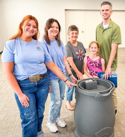 Accompanied by his youngest daughter, Kenney Keys claims the rainwater harvesting barrel drawing at the conclusion of the Tuesday, April 21 workshop. From left: Jacy Lampe, Jordan Altman, Saunna Blacksher, Mackenzie Keys and K. Keys. BEV ODOM/THE GREENBELT INTREPID