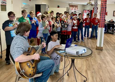 Childress Elementary School fourth-grade students, accompanied by music teacher Andrew Moore, recently perform Christmas carols for Childress Healthcare Center residents. Photo Courtesy of Childress Elementary