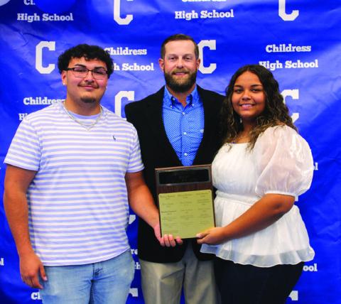 Head powerlifting coach Matthew Olson, center, awards Lady Cat Powerlifting Most Valuable Player (MVP) Rebekkah Gorman, right, and Bobcat Powerlifting MVP Adrian Macias, left.