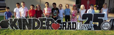 On their way to their kindergarten graduation, Kacy Cabbell’s Wellington Elementary School students admire the yardcard sign in their honor. From left: Jonah Akemon, Jayden Alvarado, Drake Barlow, Dallas Castor, Kenleigh Cummings, Yahir Estrada, Diego Gonzales, Andrew Hughs, Alias Jones, Brantley Kemp, Blake Lemons, Ezekiel Rivera, Evelyn Sanchez, Whitney Souder. Wellington Elementary Sparklers