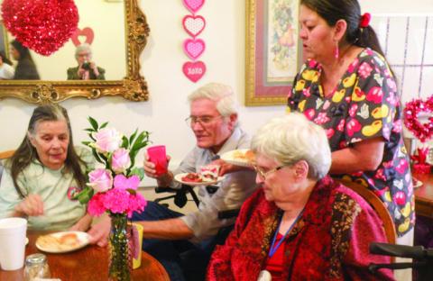 Cottage Village Assisted Living Facility residents celebrate Valentine’s Day with a mid-afternoon party. Hosted by staff, party assistance was provided by Lila Hoobler, Anne Fromm and Joe Robinson, shown with Linda Hunter, left, and Frances Weatherbee, right. Serving is Cottage Village cook Esther Martinez.