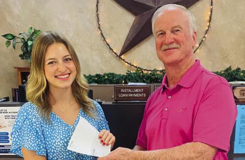 Wellington High School Class of 2024 Valedictorian Summer Neufeld accepts a $2,000 scholarship award Thursday, Aug. 8 from Wellington State Bank (WSB) President Richard Sims. An employee at WSB for the past two summers, Neufeld has enrolled in Texas Tech University in Lubbock to study finance. Her minor is interior design. Her goal is to pursue a career in the banking field after college. Courtesy Photo