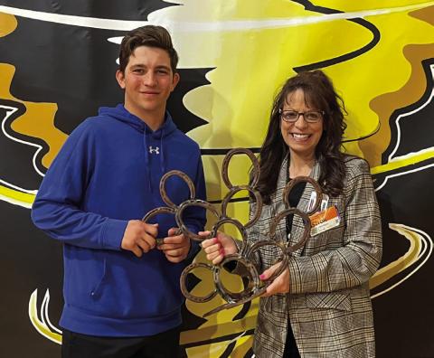 Memphis High School senior Jase Middleton presents a cactus sculpture, which he welded out of horseshoes at the Memphis Independent School District (ISD) Career Training Center, to Region 16 Education Service Center Coordinator of Accountability, Assessment and School Improvement Christine Scroggs. Photo Courtesy of Memphis ISD