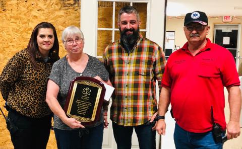 Wellington Emergency Medical Service commends Pat Needham for 35 years of dedicated and loyal service to the community as a first responder. “Your hard work is unmatched,” reads her plaque. From left, Samantha Blacksher, Needham, Noah Downing, Farris Nation. The Red River Sun/Bev Odom