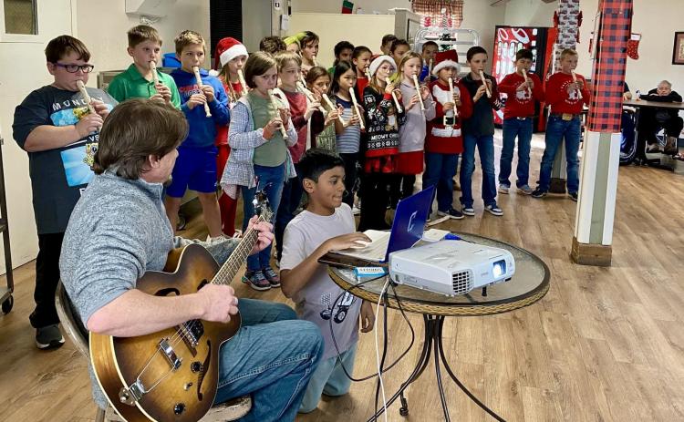 Childress Elementary School fourth-grade students, accompanied by music teacher Andrew Moore, recently perform Christmas carols for Childress Healthcare Center residents. Photo Courtesy of Childress Elementary